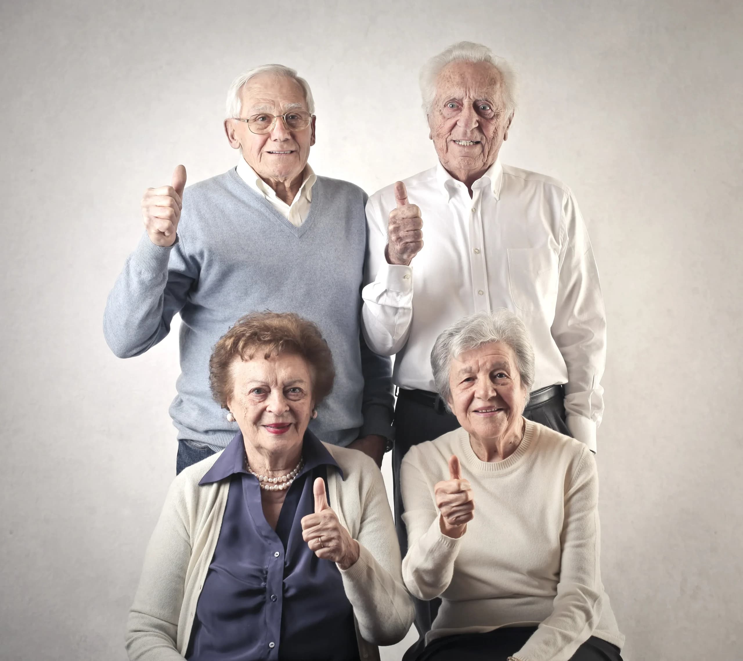 Four senior adults giving thumbs up
