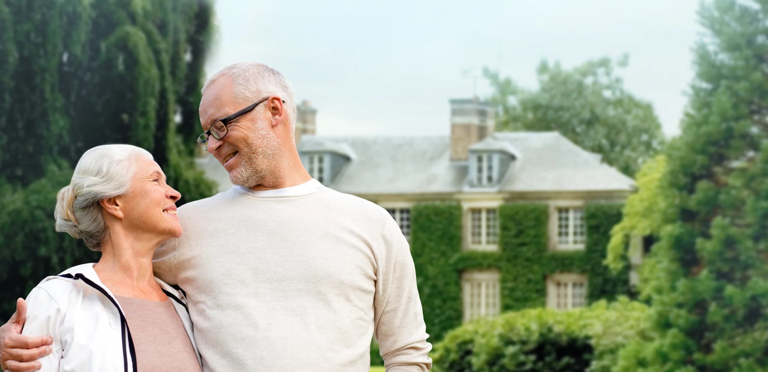 Senior couple smiling outside their home